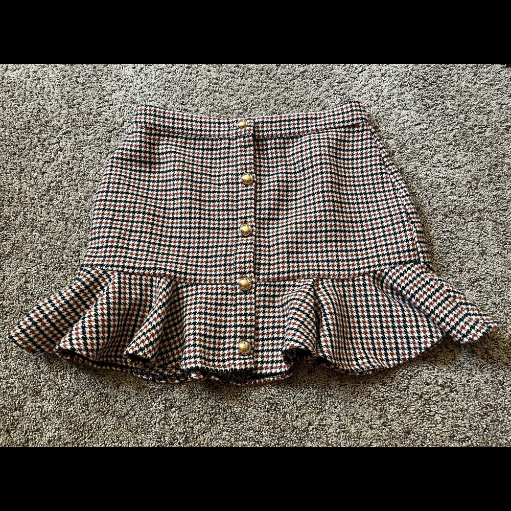 Rust orange plaid skirt with ruffles on the bottom